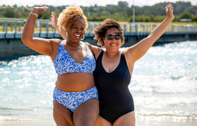 (L-R) Sima wears Reversible Plunge High Waist Bikini Set Mountain River, size 18 Hendricks; Amy wears Reversible Plunge Swimsuit Leopard & Black, size 16 Hendricks